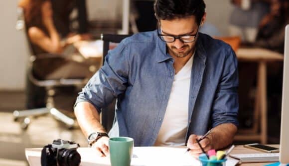 Yrittäjä työpöydän ääressä selvittämässä miten selvitä asiakkaiden pitkistä maksuehdoista